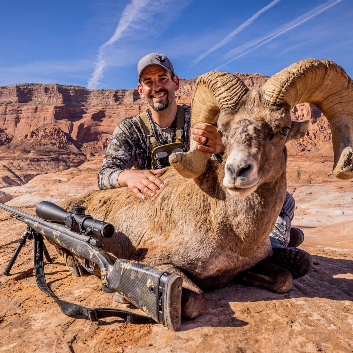 Hunter with a bighorn sheep in a canyon setting