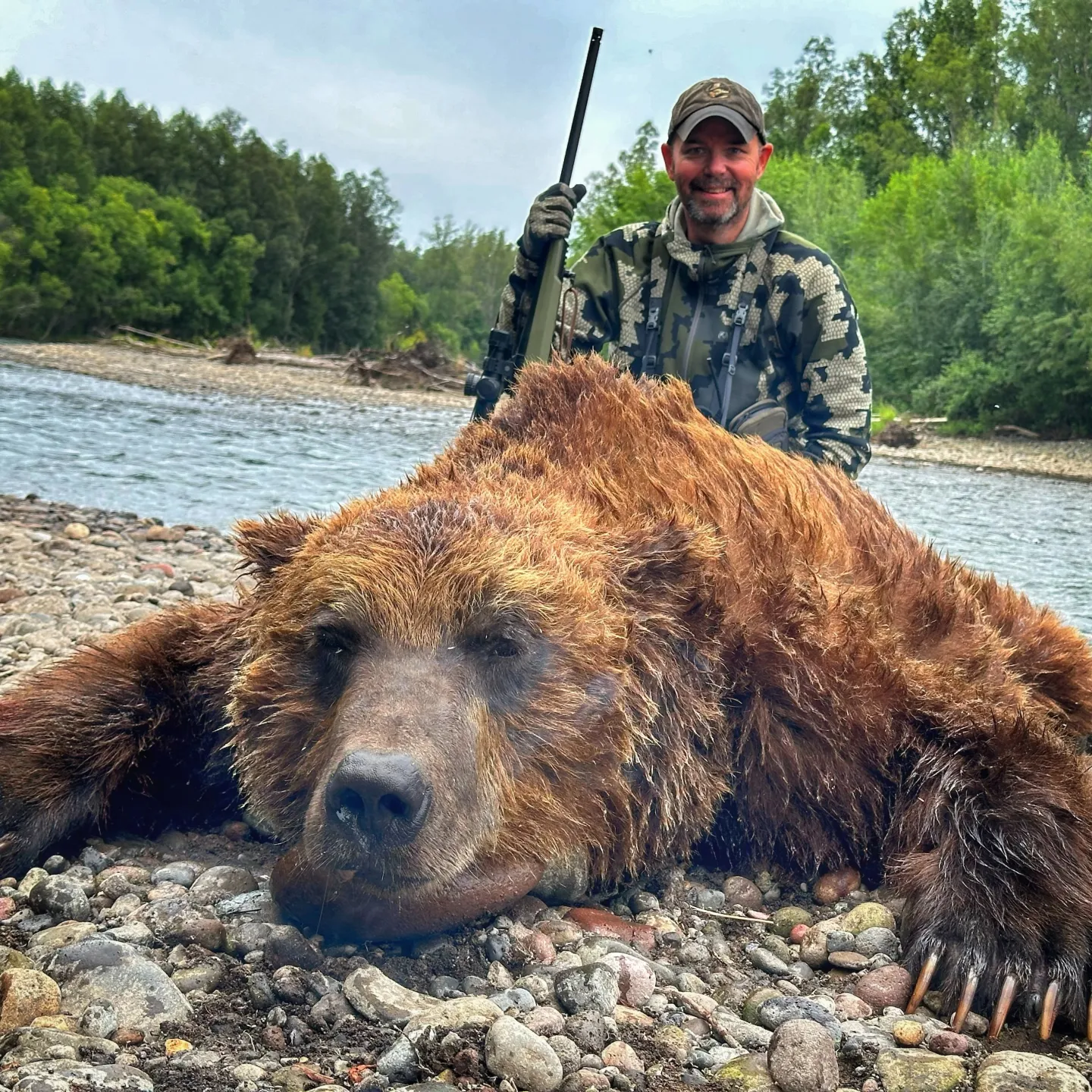 Gunwerks customer with a large brown bear by a river.