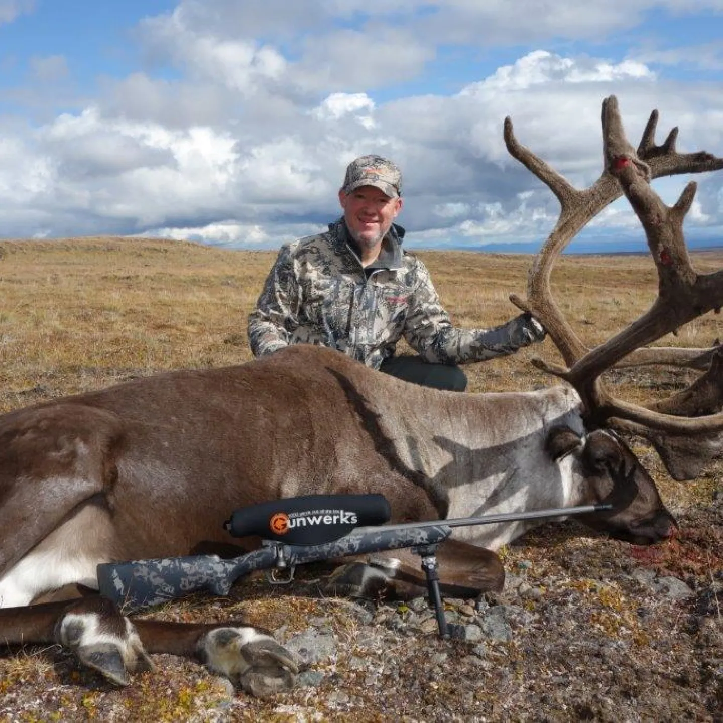 Gunwerks customer with a harvested caribou in a tundre landscape